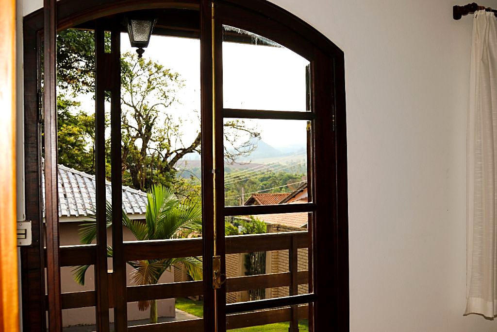 Vista da janela de um chalé da Villa Donn'Anna em Analândia (SP), com o vale e os morros ao fundo