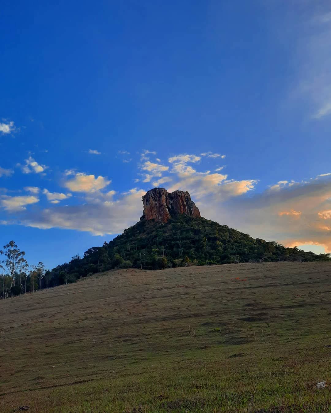 Morro do Cuscuzeiro em Analândia (SP), com pastagem em primeiro plano e céu ao entardecer